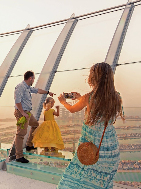 Family taking a photo at View at The Palm, Dubai, overlooking the Palm Jumeirah.