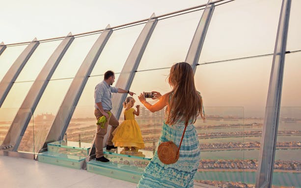 Family taking a photo at View at The Palm, Dubai, overlooking the Palm Jumeirah.