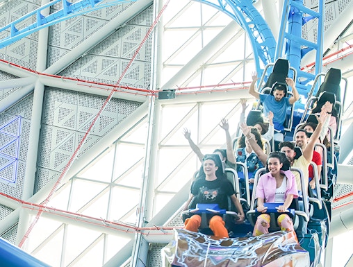 Riders on the Storm Coaster at Dubai Hills Mall, experiencing a thrilling indoor loop.