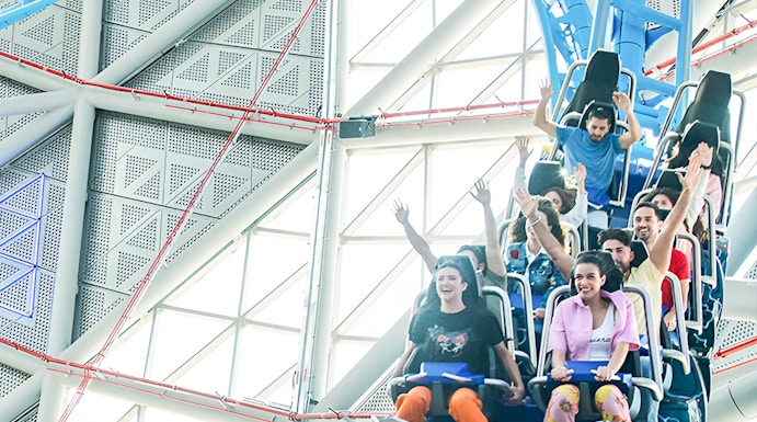 Riders on the Storm Coaster at Dubai Hills Mall, experiencing a thrilling indoor loop.