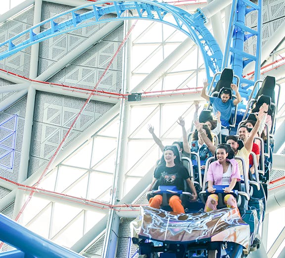 Riders on the Storm Coaster at Dubai Hills Mall, experiencing a thrilling indoor loop.
