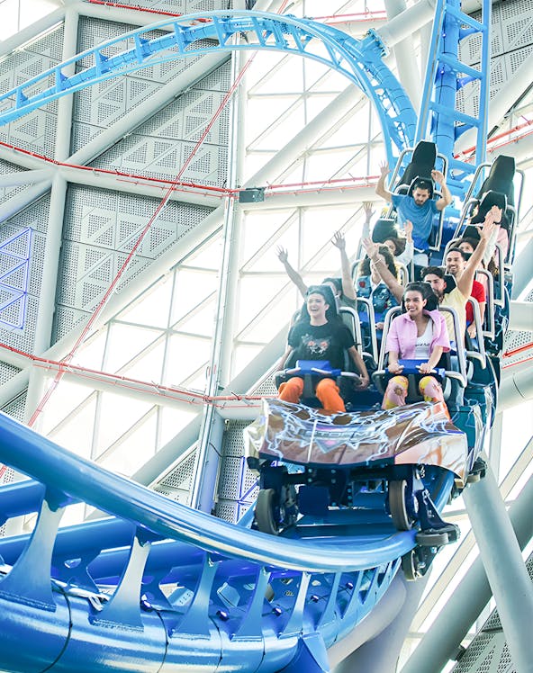 Riders on the Storm Coaster at Dubai Hills Mall, experiencing a thrilling indoor loop.
