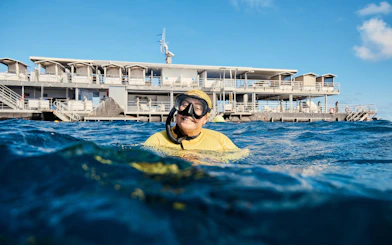 Snorkeler in front of a floating platform during Whitehaven Beach tour, Whitsundays.