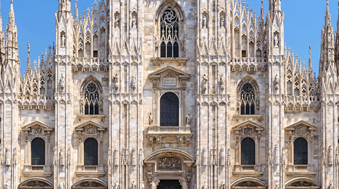Duomo Milan Cathedral facade with tourists in the square.