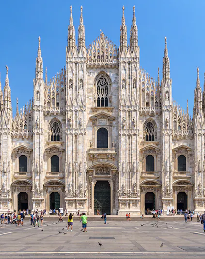 Duomo Milan Cathedral facade with tourists in the square.