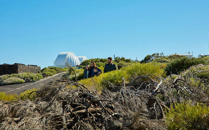 Guests exploring Teide Observatory grounds with domes in the background.