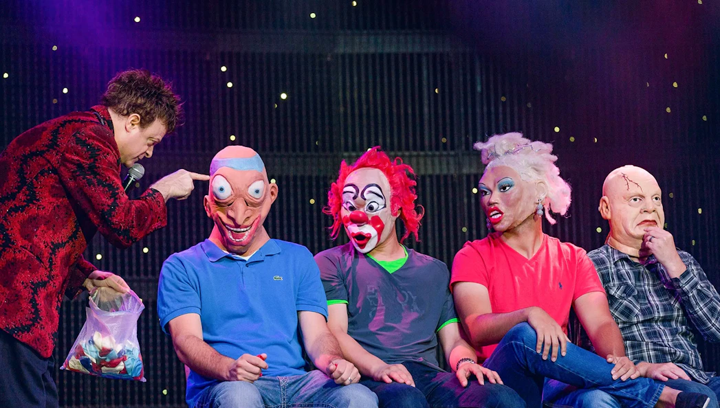 Performer interacting with masked participants at V - The Ultimate Variety Show.