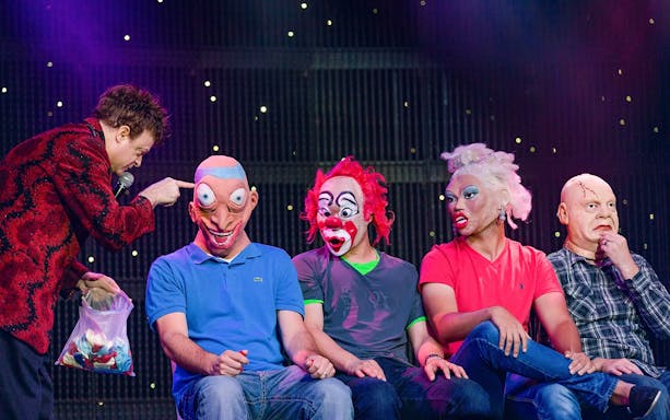 Performer interacting with masked participants at V - The Ultimate Variety Show.