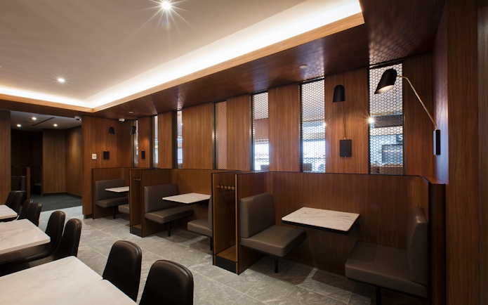 Seating area inside Plaza Premium Lounge with wooden decor and marble tables.