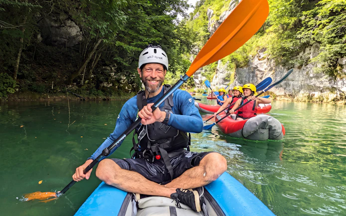 Tourists kayaking in Mrežnica Canyon, Split, surrounded by lush greenery and rocky cliffs.