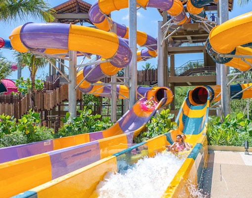 Water slide at Andamanda Phuket water park, Thailand, featuring vibrant colors and twists.