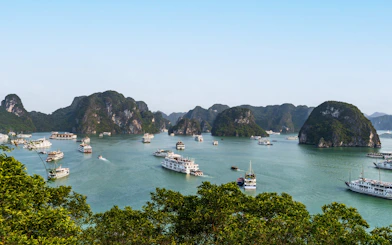 Panoramic view of Ha Long Bay with boats and limestone islands from Ti Top Island peak.