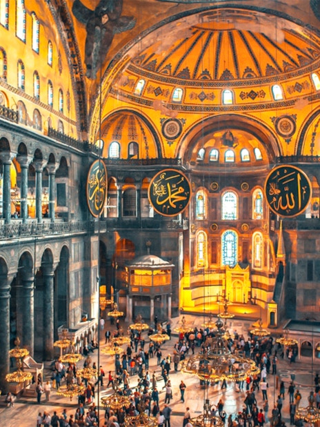 Interior view of Hagia Sophia with visitors exploring the historic architecture in Istanbul.
