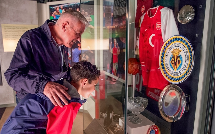 Tourists viewing Arsenal memorabilia at Emirates Stadium on a combo tour with Tower of London.
