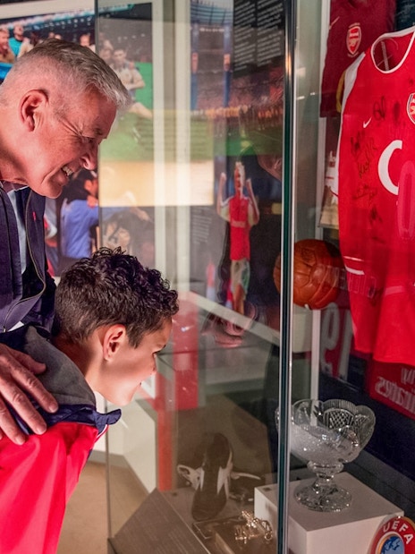 Visitors viewing Arsenal memorabilia at Emirates Stadium tour, London.