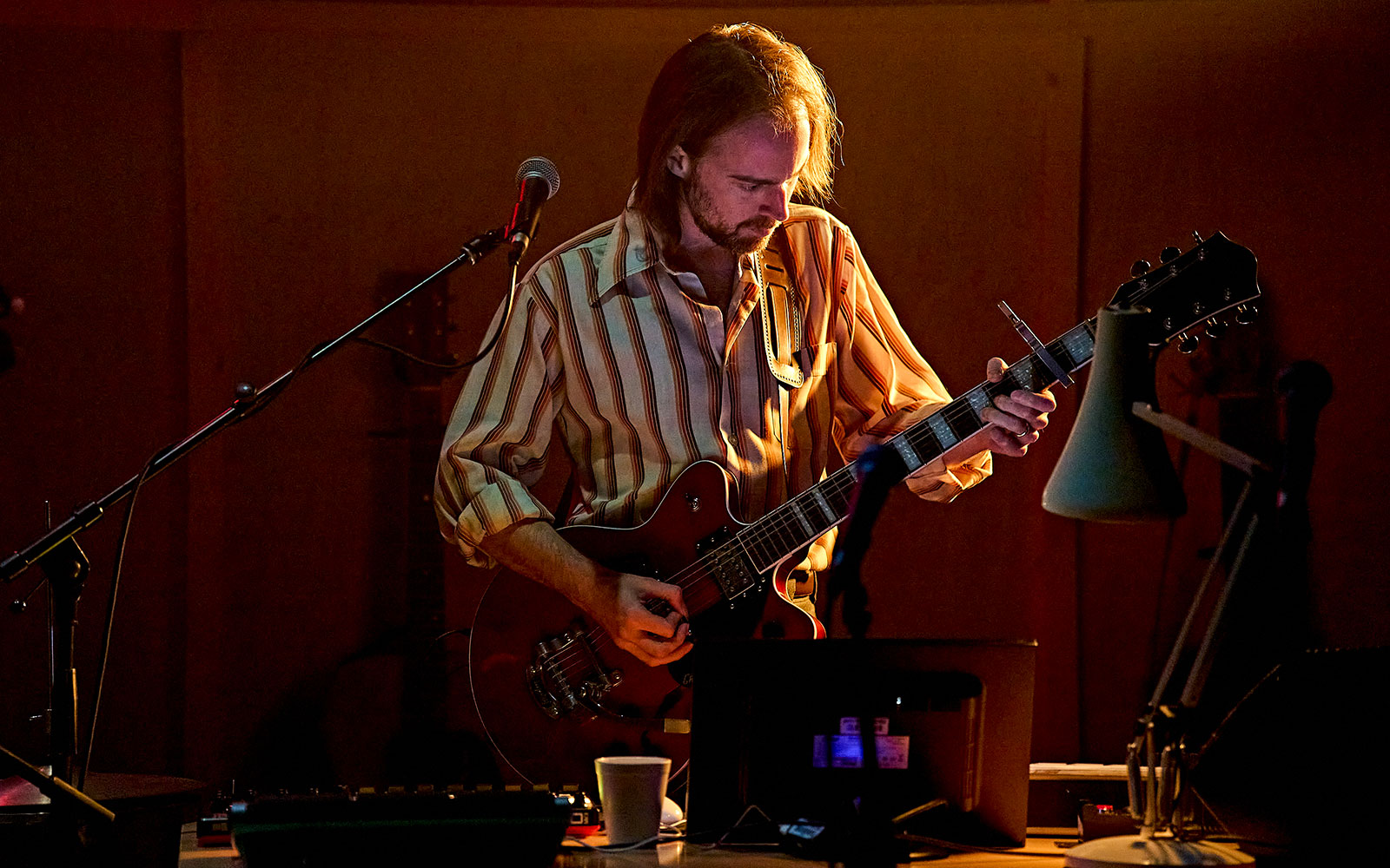 Musician playing guitar on stage during Kenrex performance.