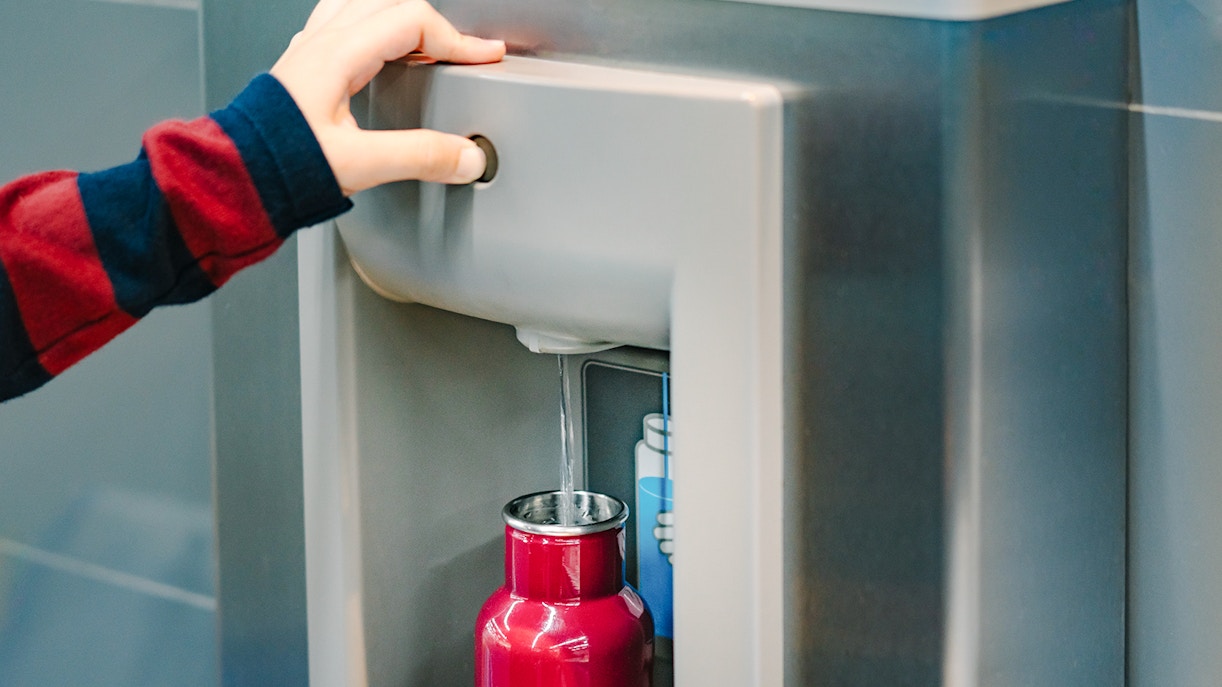 Filling a red bottle at Nausicaá Aquarium water refill station.