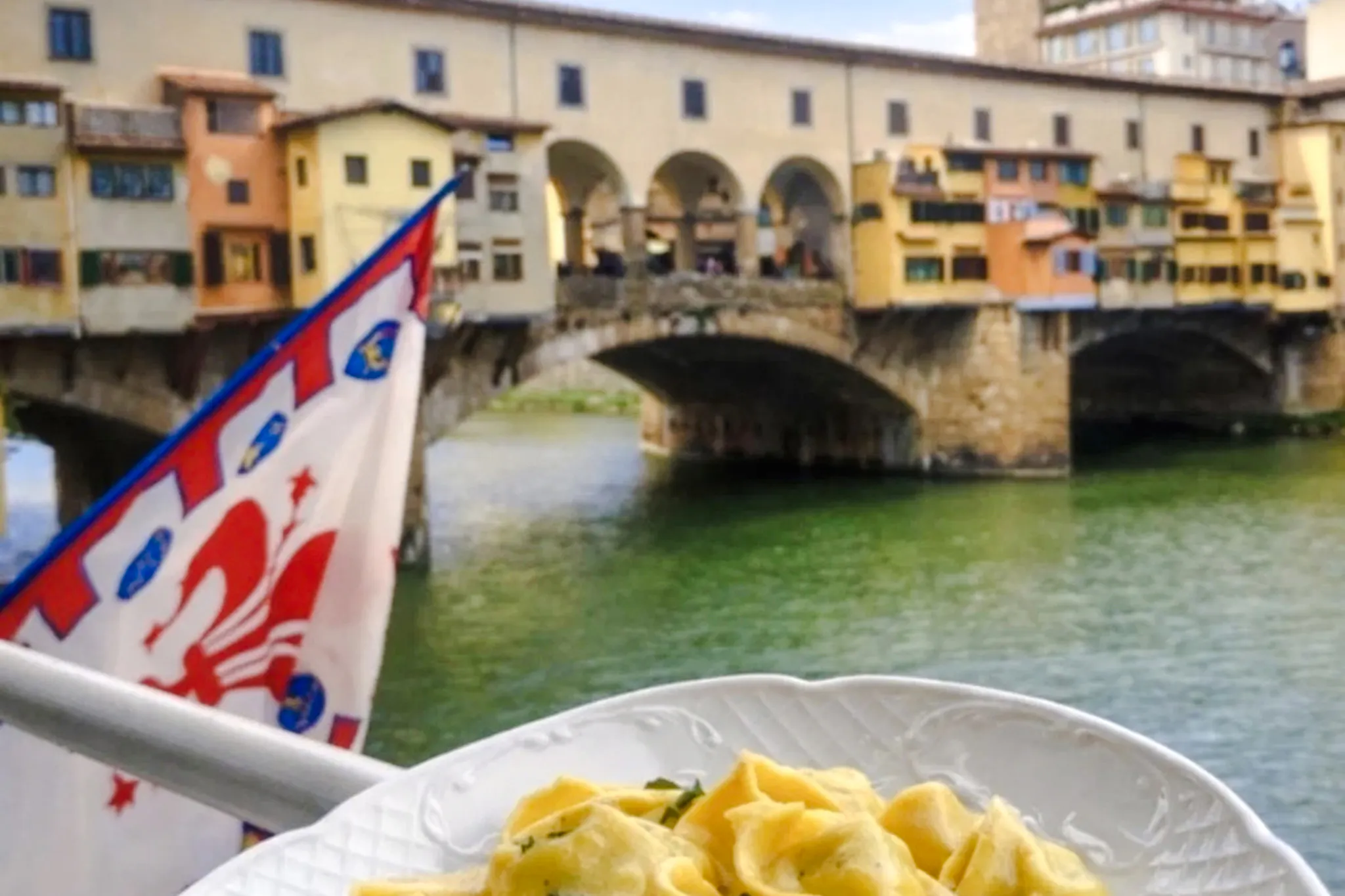 Pasta dish with Ponte Vecchio view in Florence during small-group cooking class.
