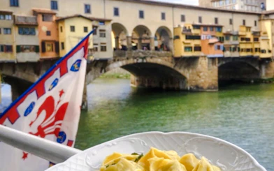 Pasta dish with Ponte Vecchio view in Florence during small-group cooking class.