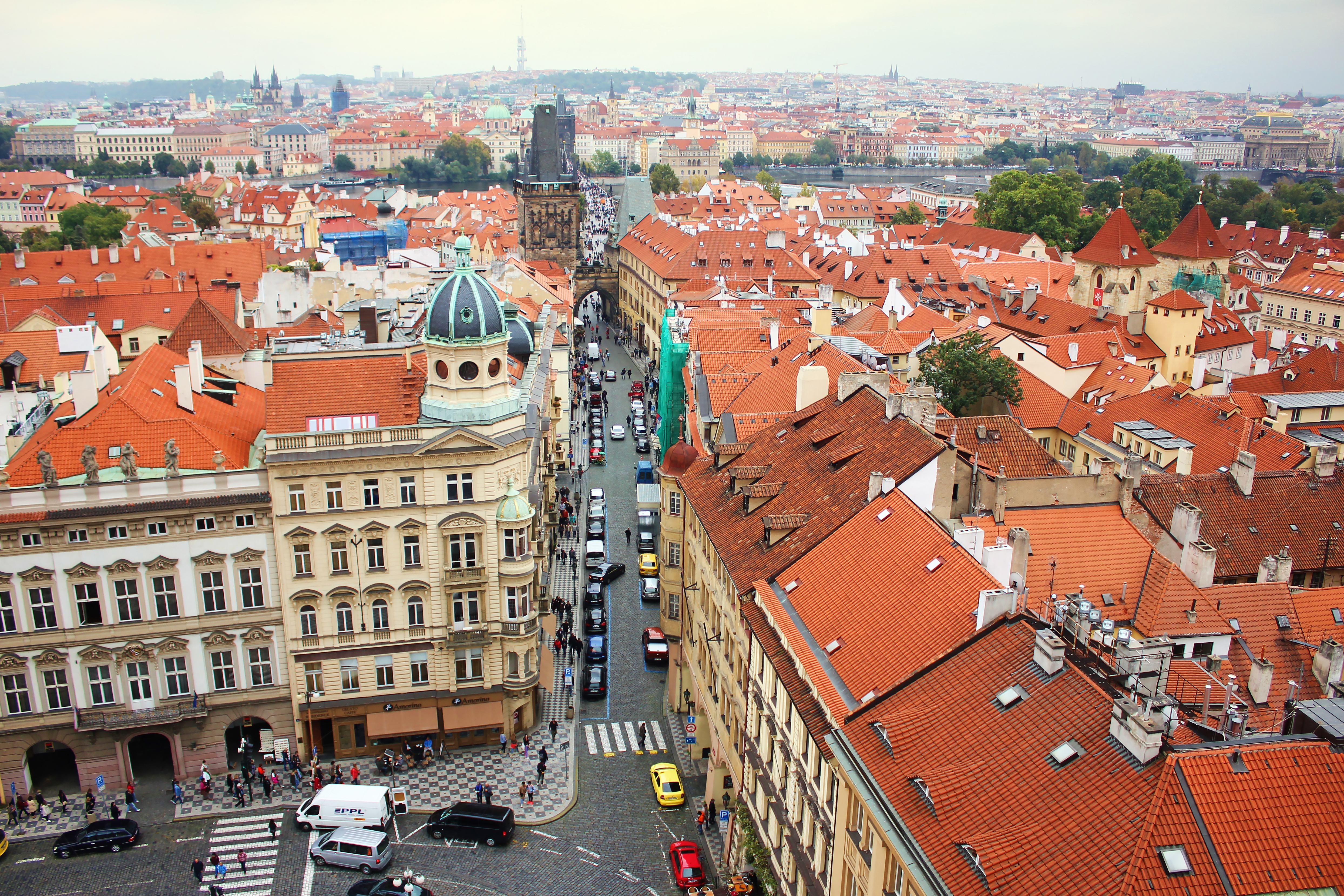 Aerial view of Mostecka street near St Nicholas Bell Tower, Prague, with red rooftops and historic buildings.
