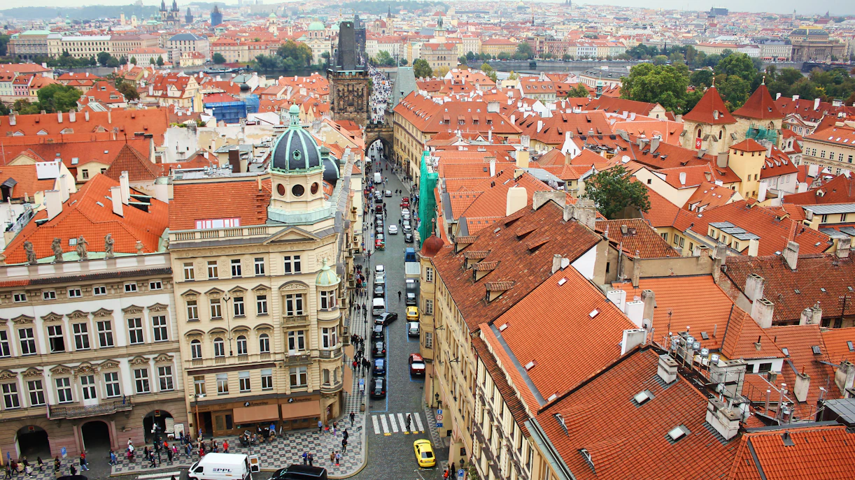 Aerial view of Mostecka street near St Nicholas Bell Tower, Prague, with red rooftops and historic buildings.