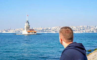 Man viewing Maiden's Tower from Istanbul's Asian side during ferry tour.
