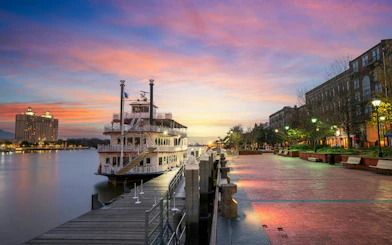 Riverboat docked at Savannah Riverwalk during sunset, part of the Savannah Captured by Pirates game.