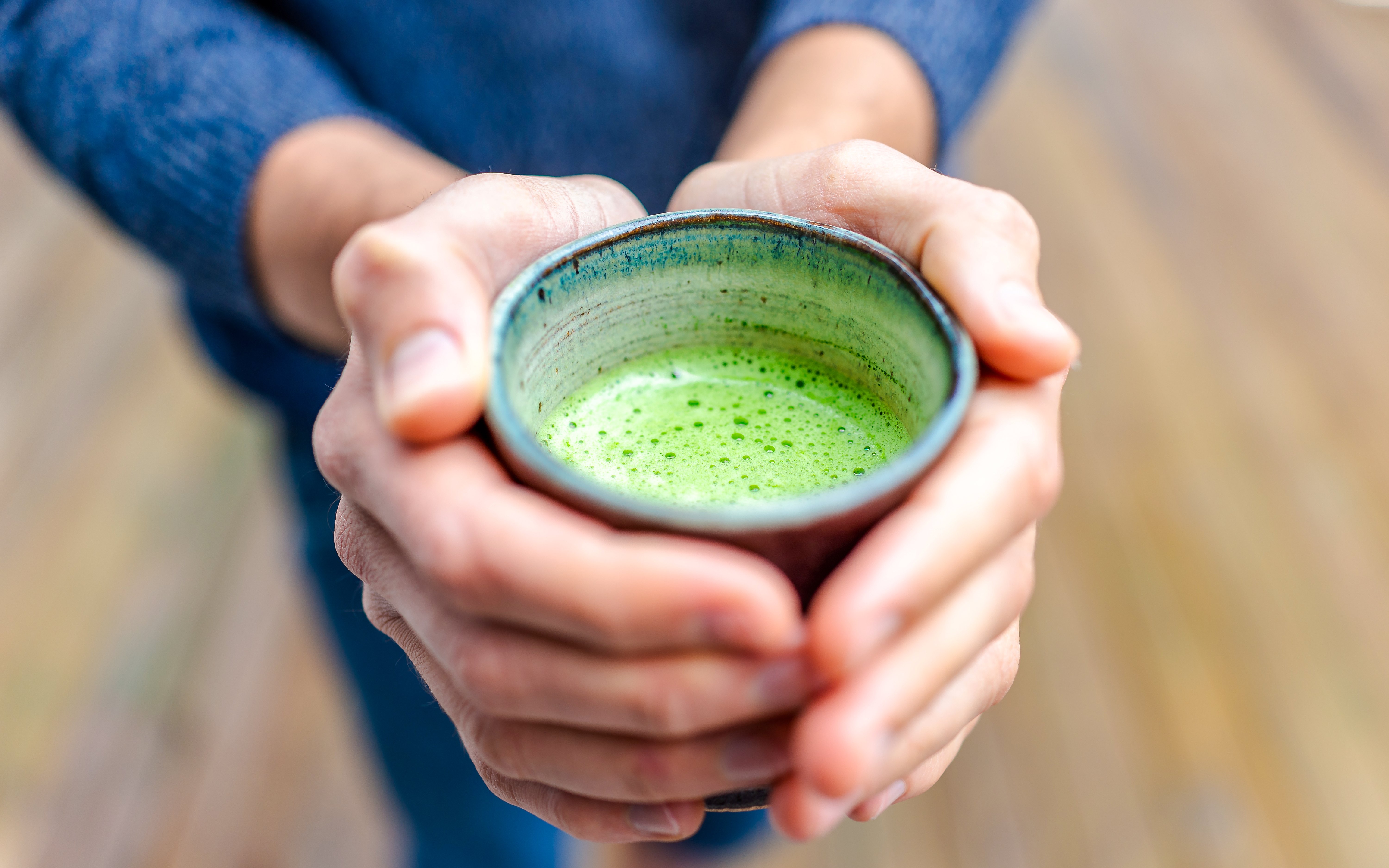 Tourist holding a cup of Matcha tea.