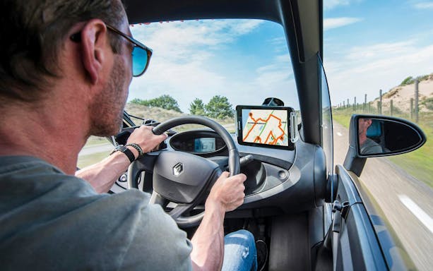Driver using GPS for self-drive audio tour at Keukenhof tulip fields.