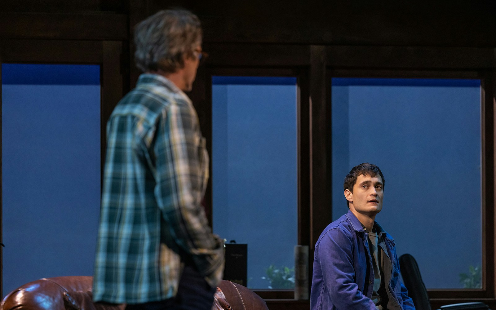 Two people in conversation in a dimly lit room, McNEAL context.