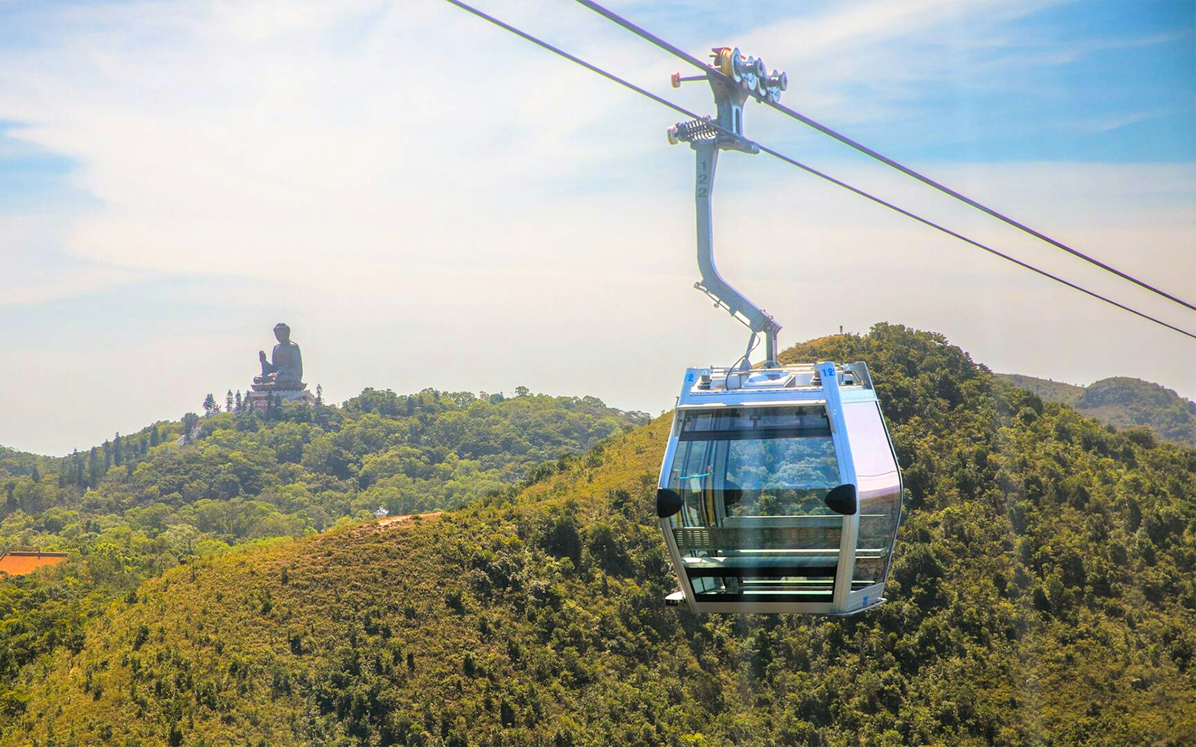 Ngong Ping Cable Car with Tian Tan Buddha in the background, Lantau Island, Hong Kong.