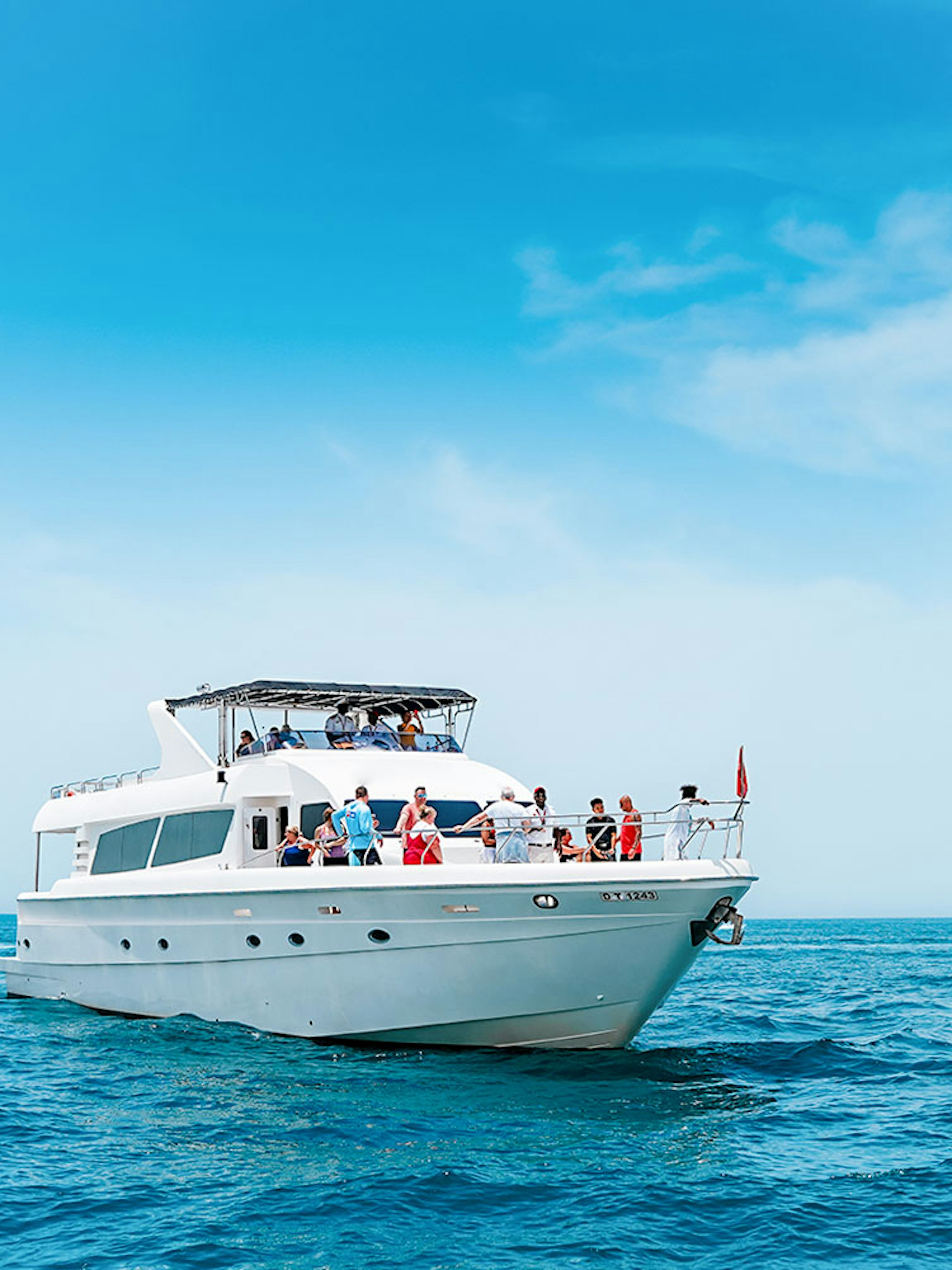 Bluewater Yacht cruising on open sea with passengers enjoying the view.