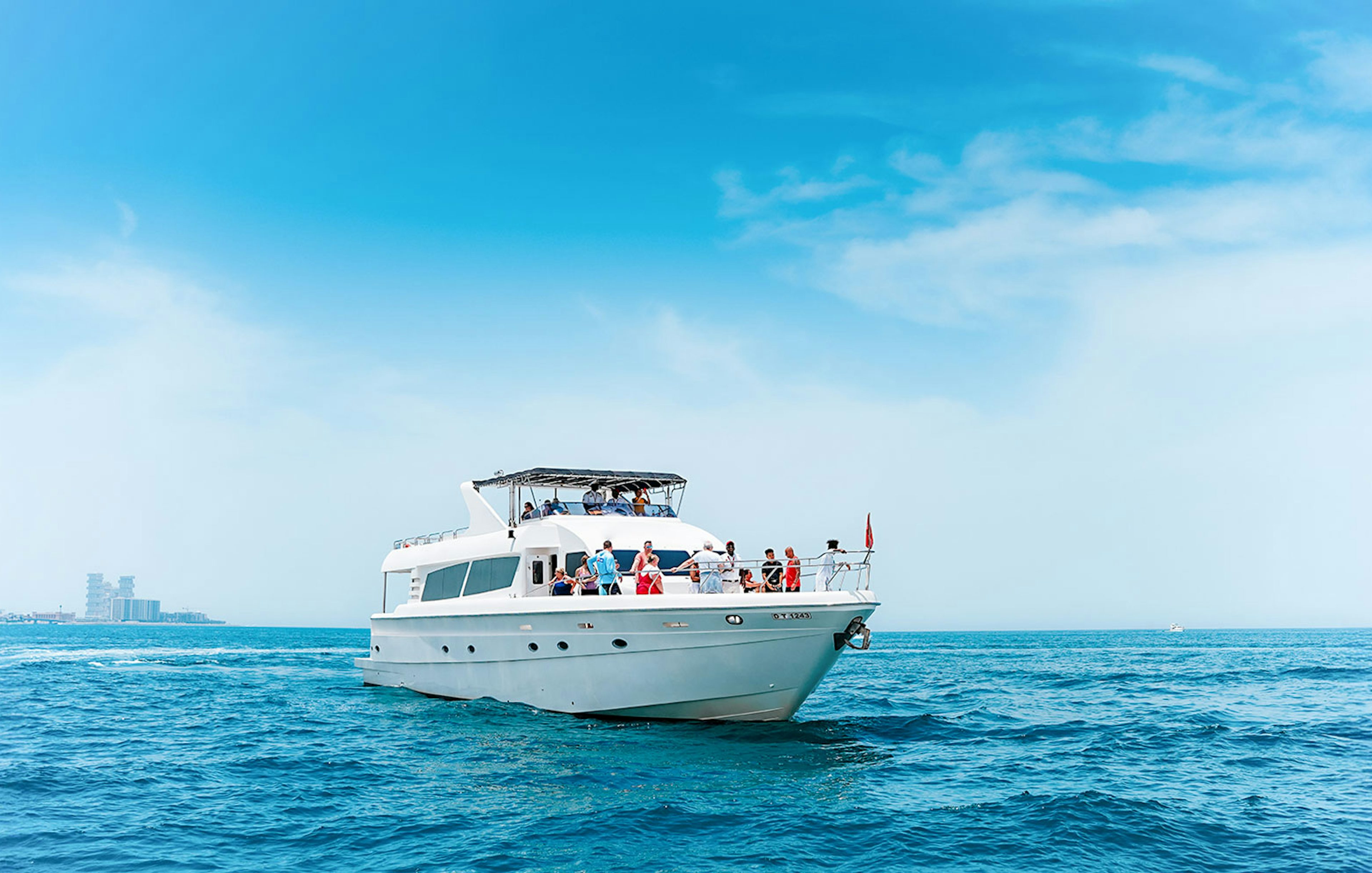 Bluewater Yacht cruising on open sea with passengers enjoying the view.