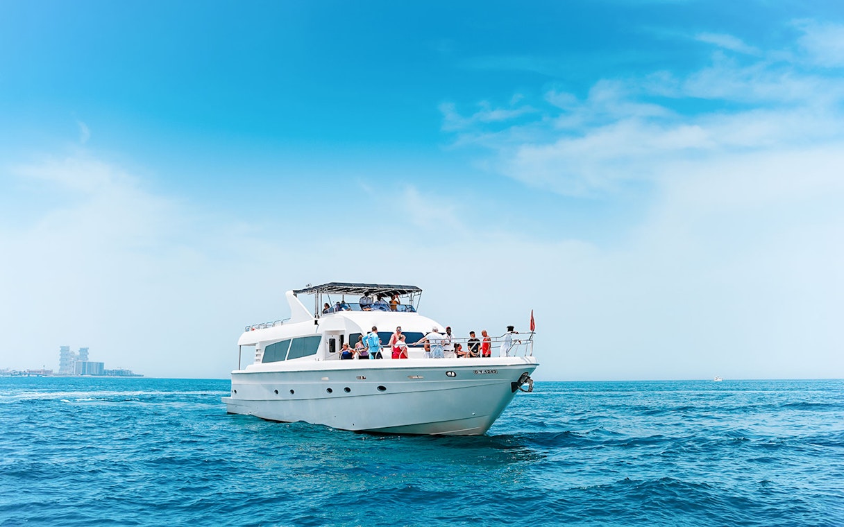 Bluewater Yacht cruising on open sea with passengers enjoying the view.