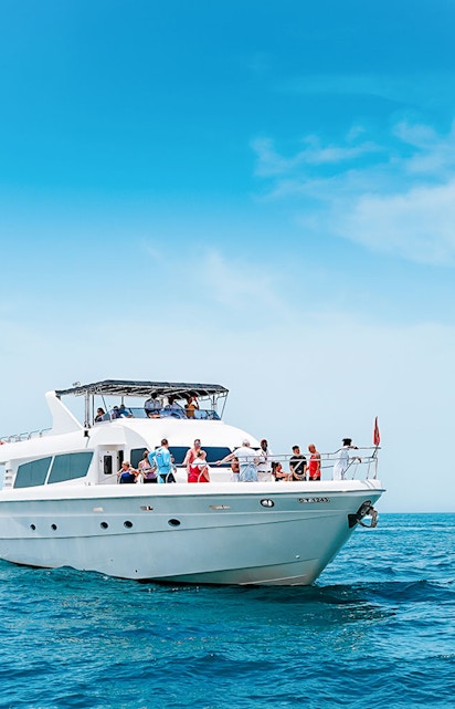 Bluewater Yacht cruising on open sea with passengers enjoying the view.