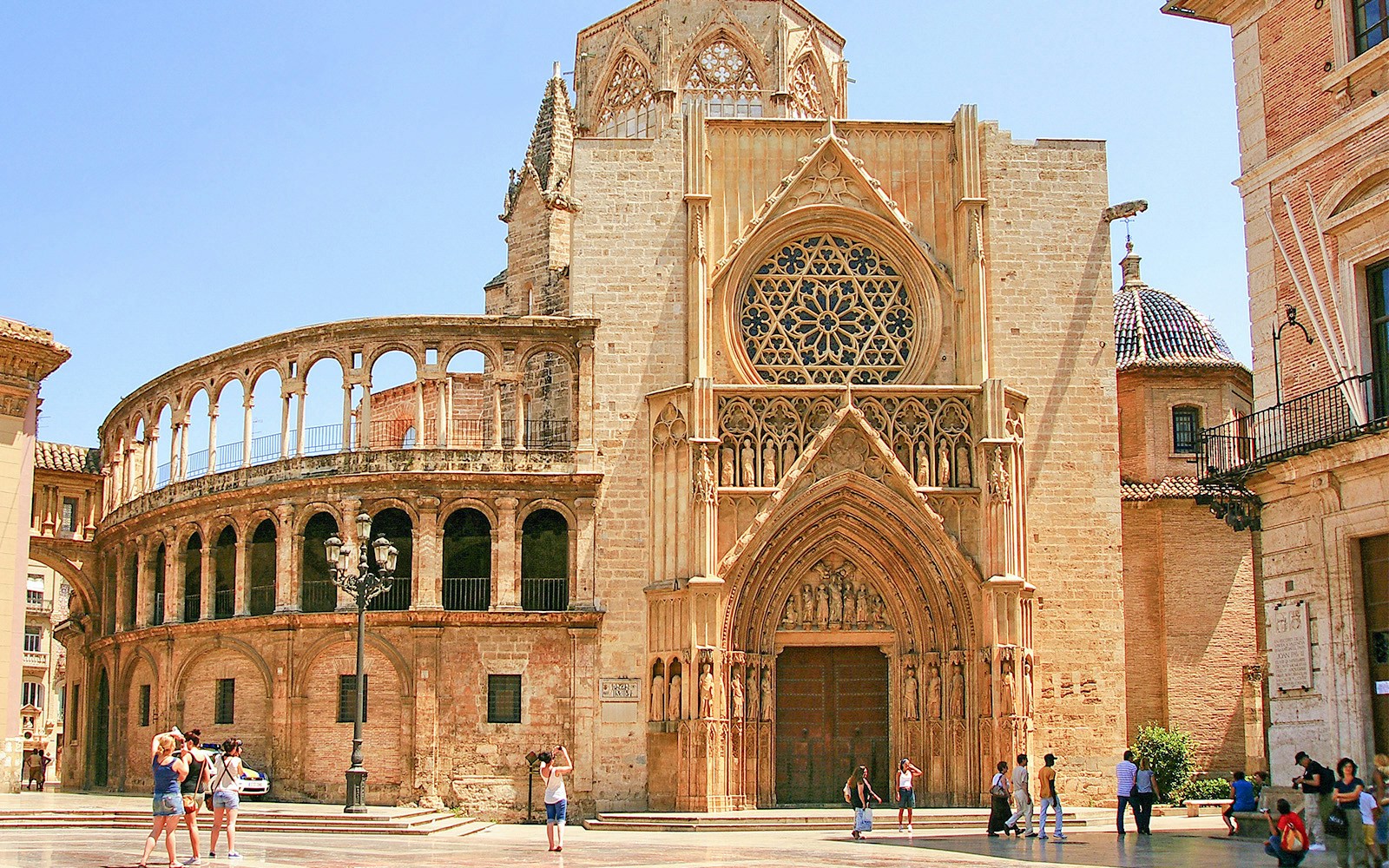 Valencia Cathedral, people walking and taking photos of yellow coloured txtures walls