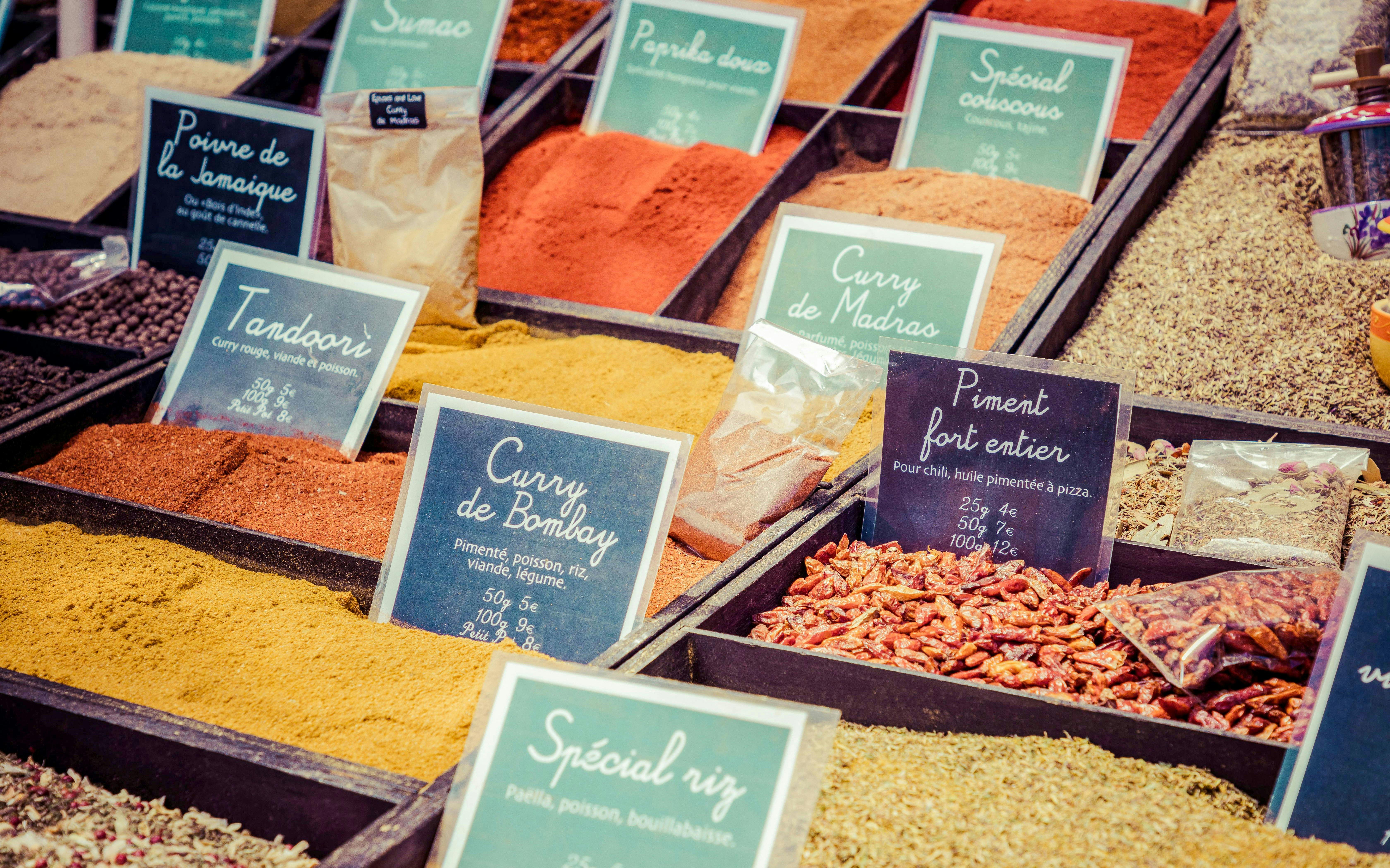 Spices displayed at a local market in Provence, featuring curry, paprika, and chili.