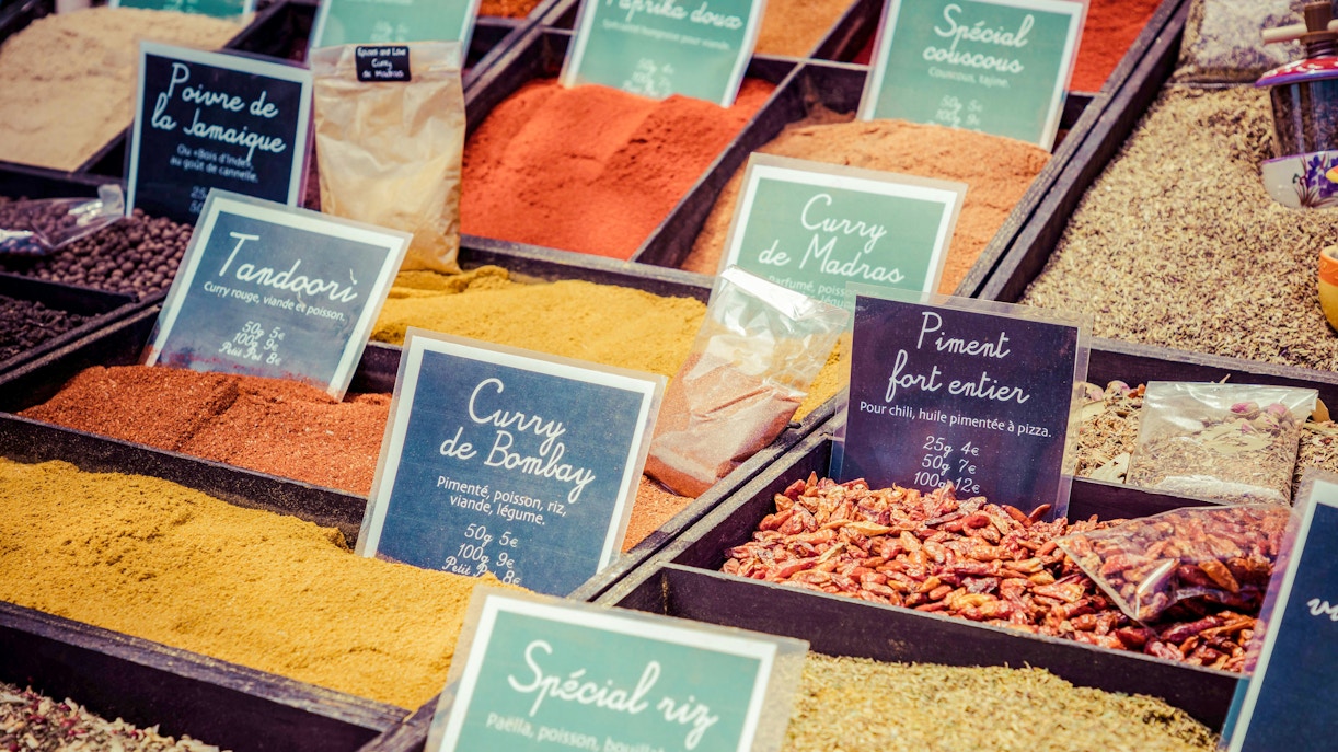 Spices displayed at a local market in Provence, featuring curry, paprika, and chili.