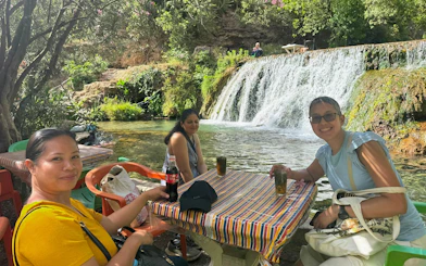 Tourists enjoying drinks by Akchour Waterfalls in Morocco.