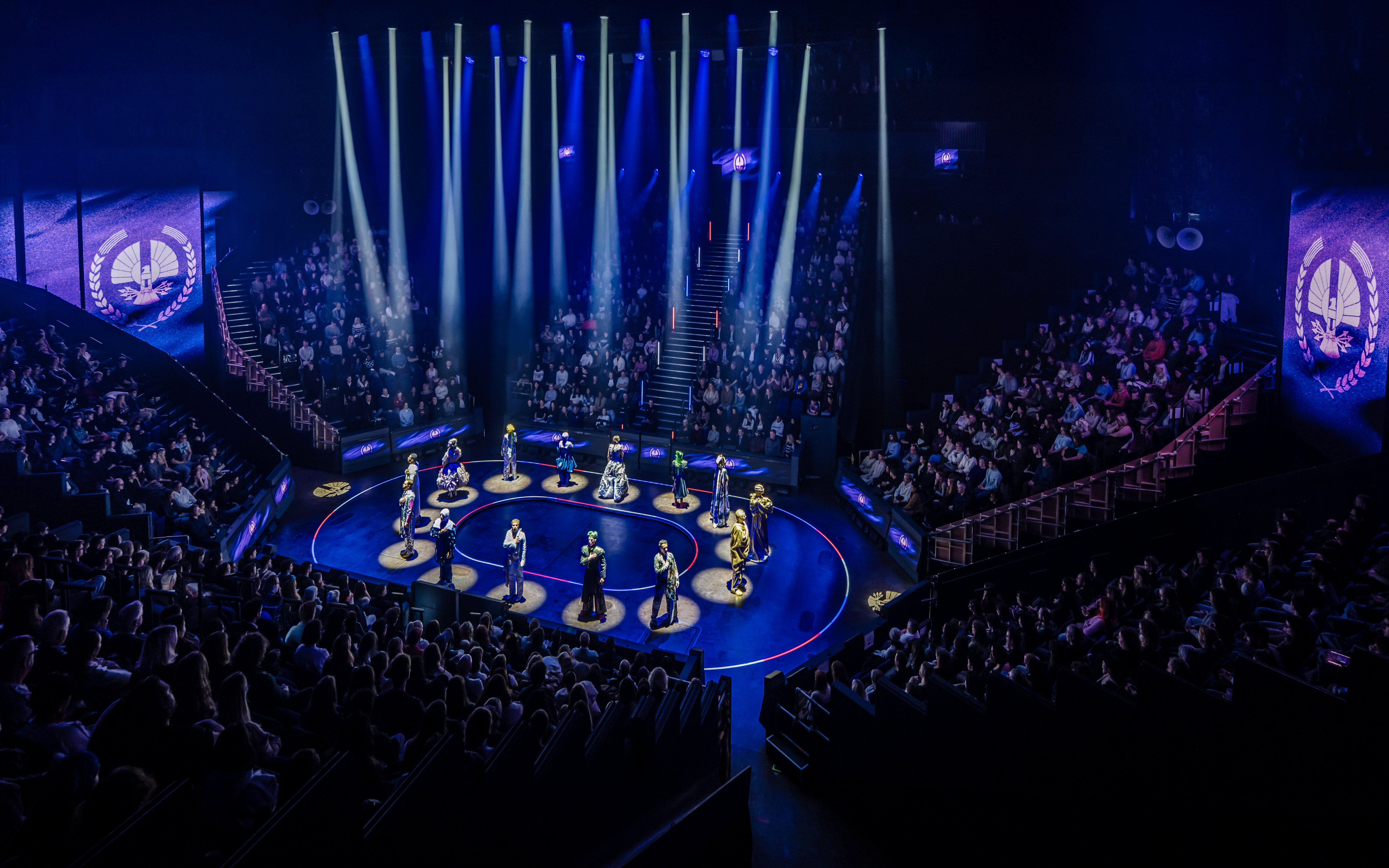 Hunger Games West End show stage performance with actors in spotlight.
