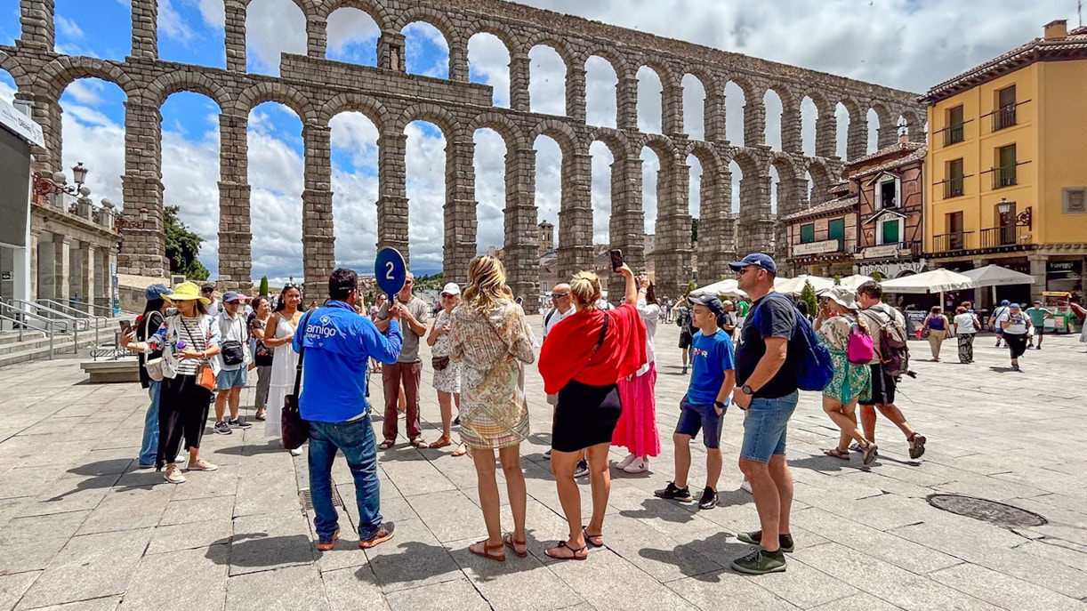 Tourists with guide at Segovia aqueduct, Spain.