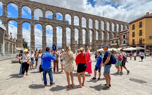 Tourists with guide at Segovia aqueduct, Spain.