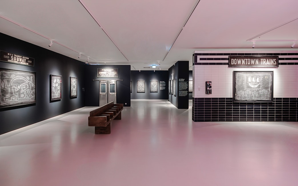 Keith Haring artworks in subway-themed room at Moco Museum London exhibit.