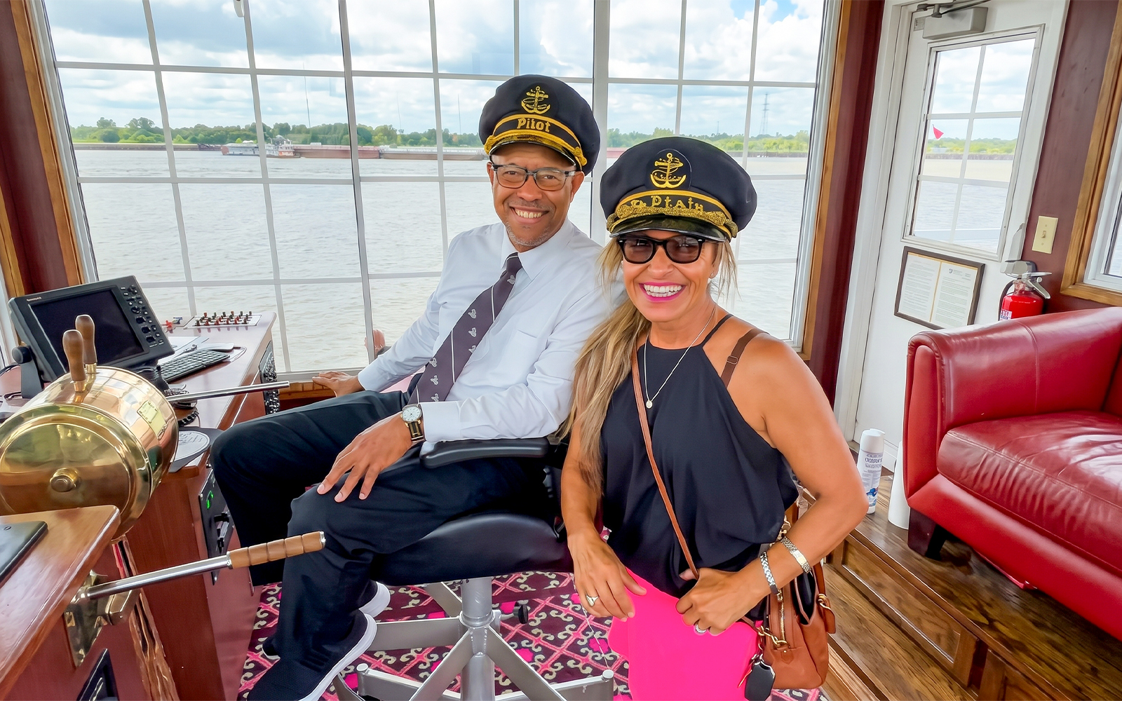 Pilot and guest in captain's hats on Riverboat City of New Orleans cruise.