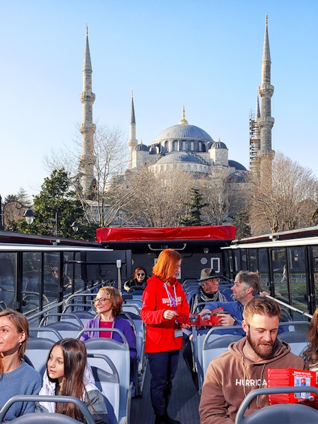 Tourists on a bus tour in Istanbul with the Blue Mosque in the background.