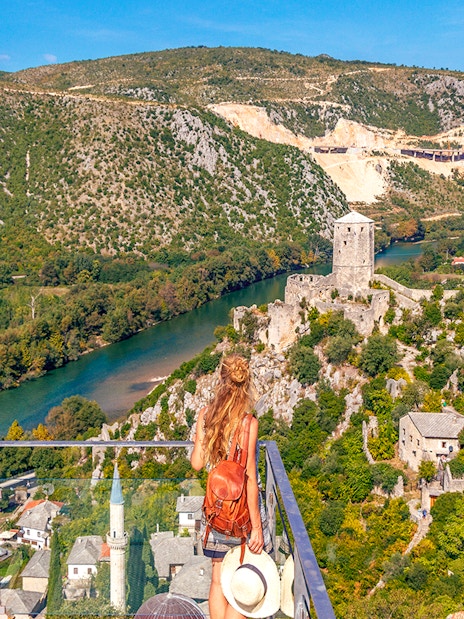 Guests overlooking Pocitelj village and river in Bosnia from a scenic viewpoint.