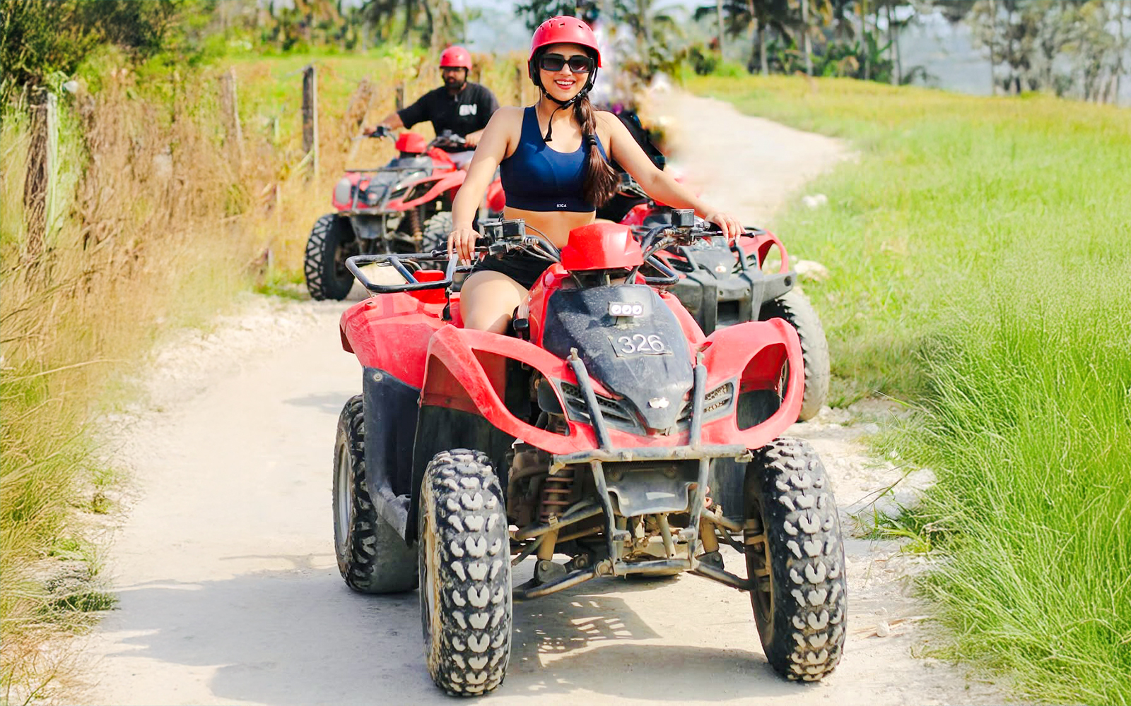 ATV riders on a dirt path near Kuber, heading towards a long tunnel.