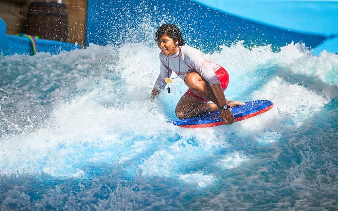 Person surfing at Wild Wadi Waterpark, Dubai.