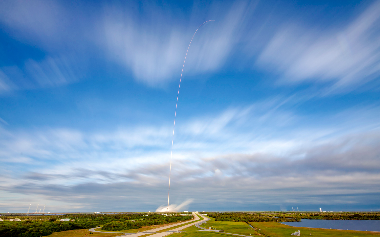 SpaceX rocket launching at Cape Canaveral, Florida, with fiery trail against the night sky.