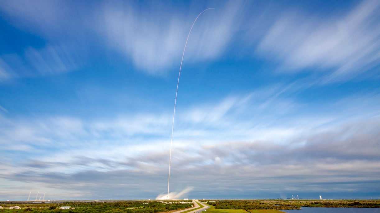 SpaceX rocket launching at Cape Canaveral, Florida, with fiery trail against the night sky.